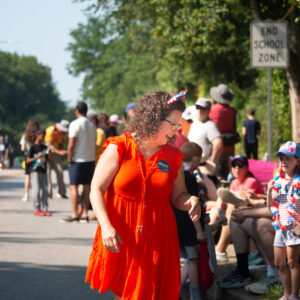 Amy Brooks walking the parade, smiling at people