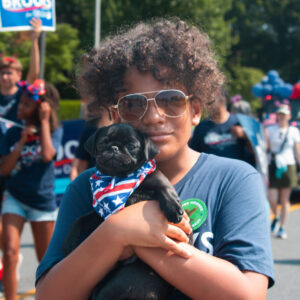Boy in a Brooks for Maryland tshirt hugging a pug