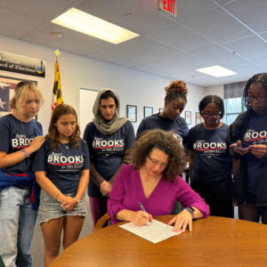 Amy Brooks signing up to run as Delegate with a group of supporters standing in behind her.