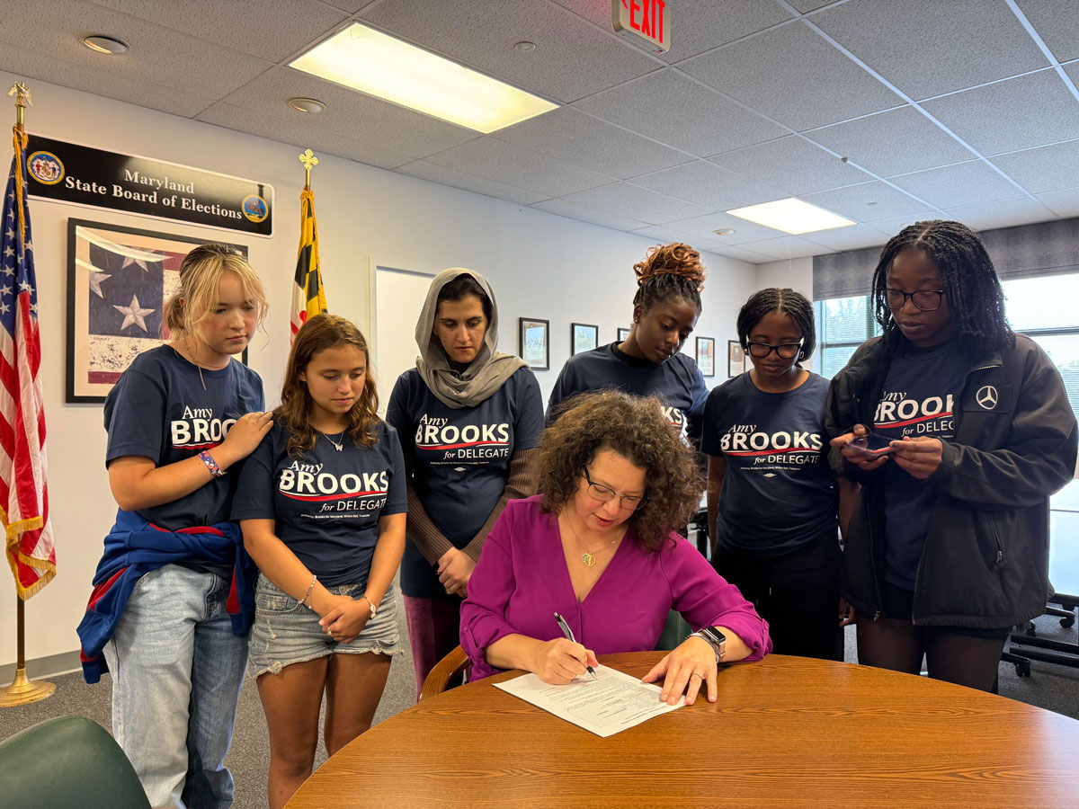 Amy Brooks signing up to run as Delegate with a group of supporters standing in behind her.